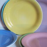 Seven pastel-colored plates mixed with vintage earthenware