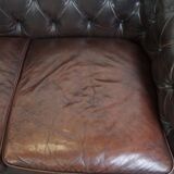 Old dark brown 3-seater cowhide chesterfield sofa with lots of character