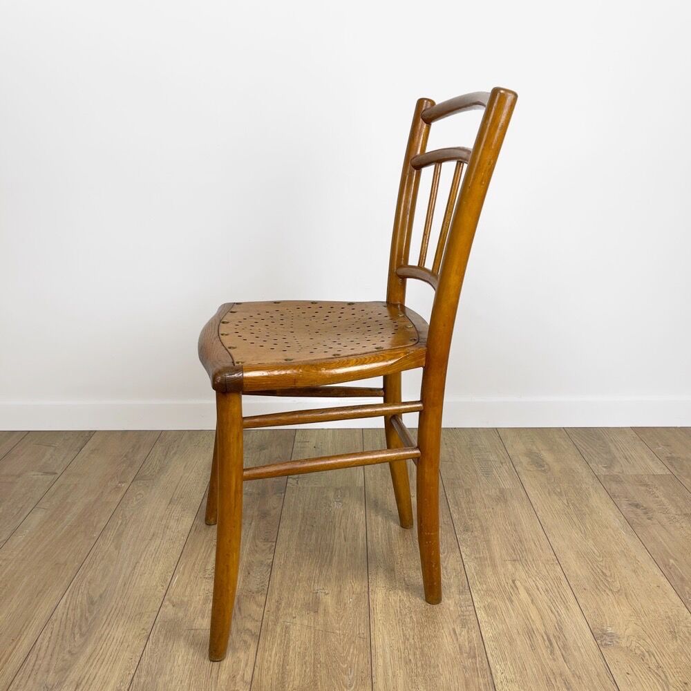 Pair of curved wood bistro chairs and studded and perforated seat