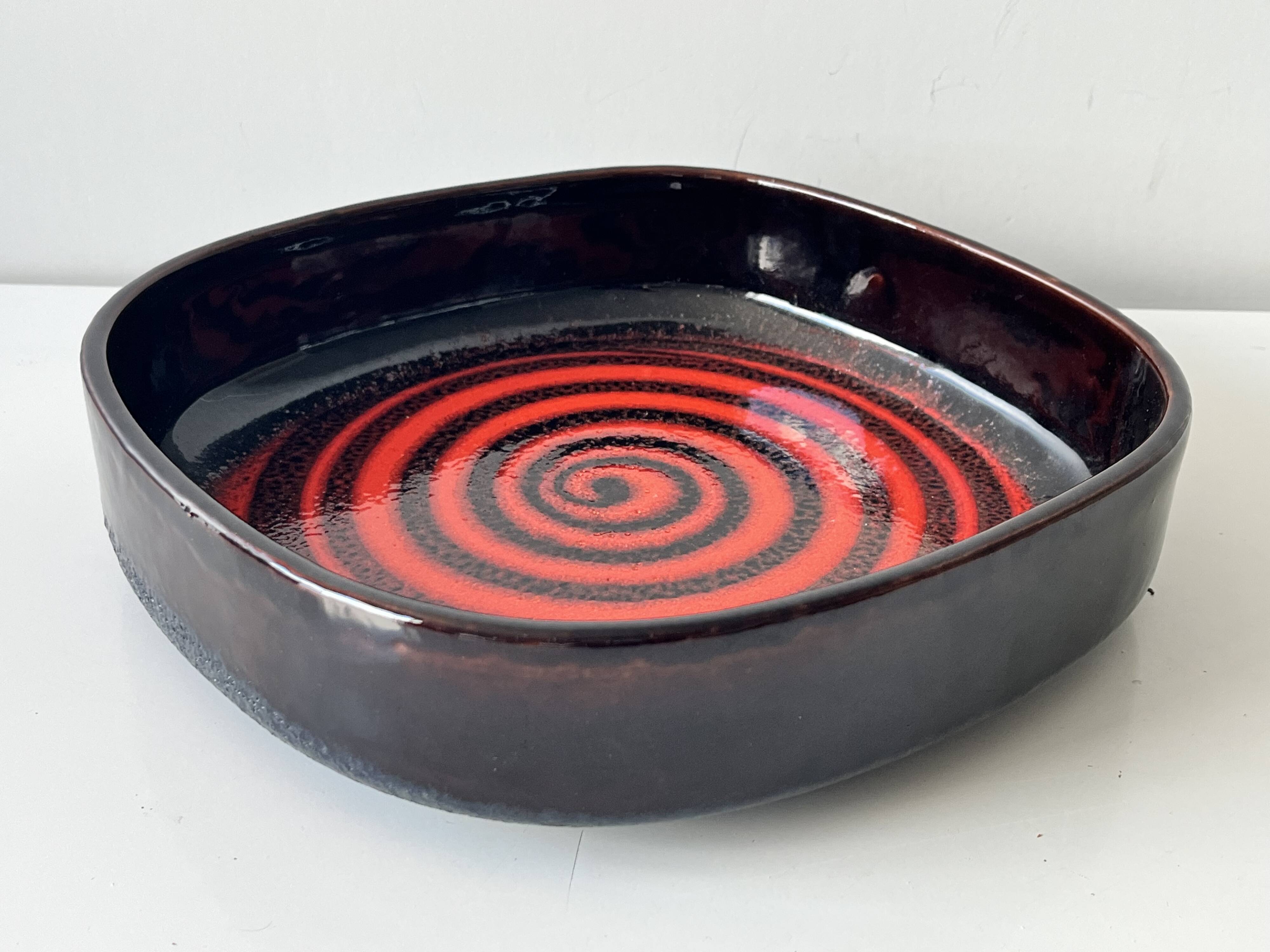 Large decorative ceramic catchall with red and black spiral pattern.