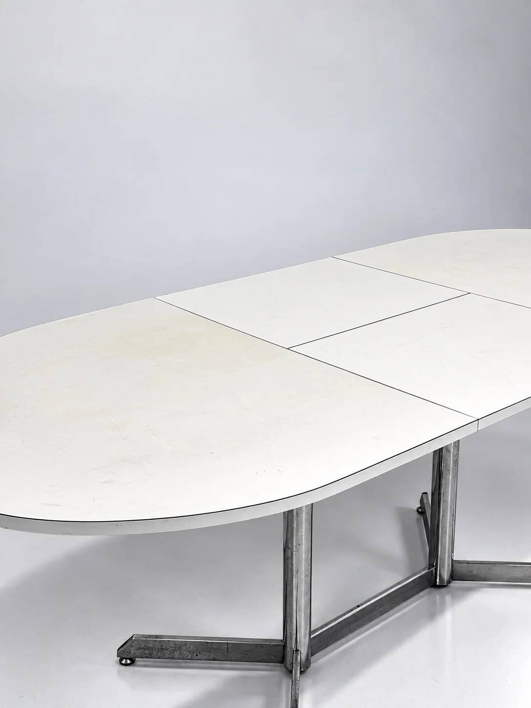 Vintage oval extendable dining table, white laminate and chrome, 1970s.