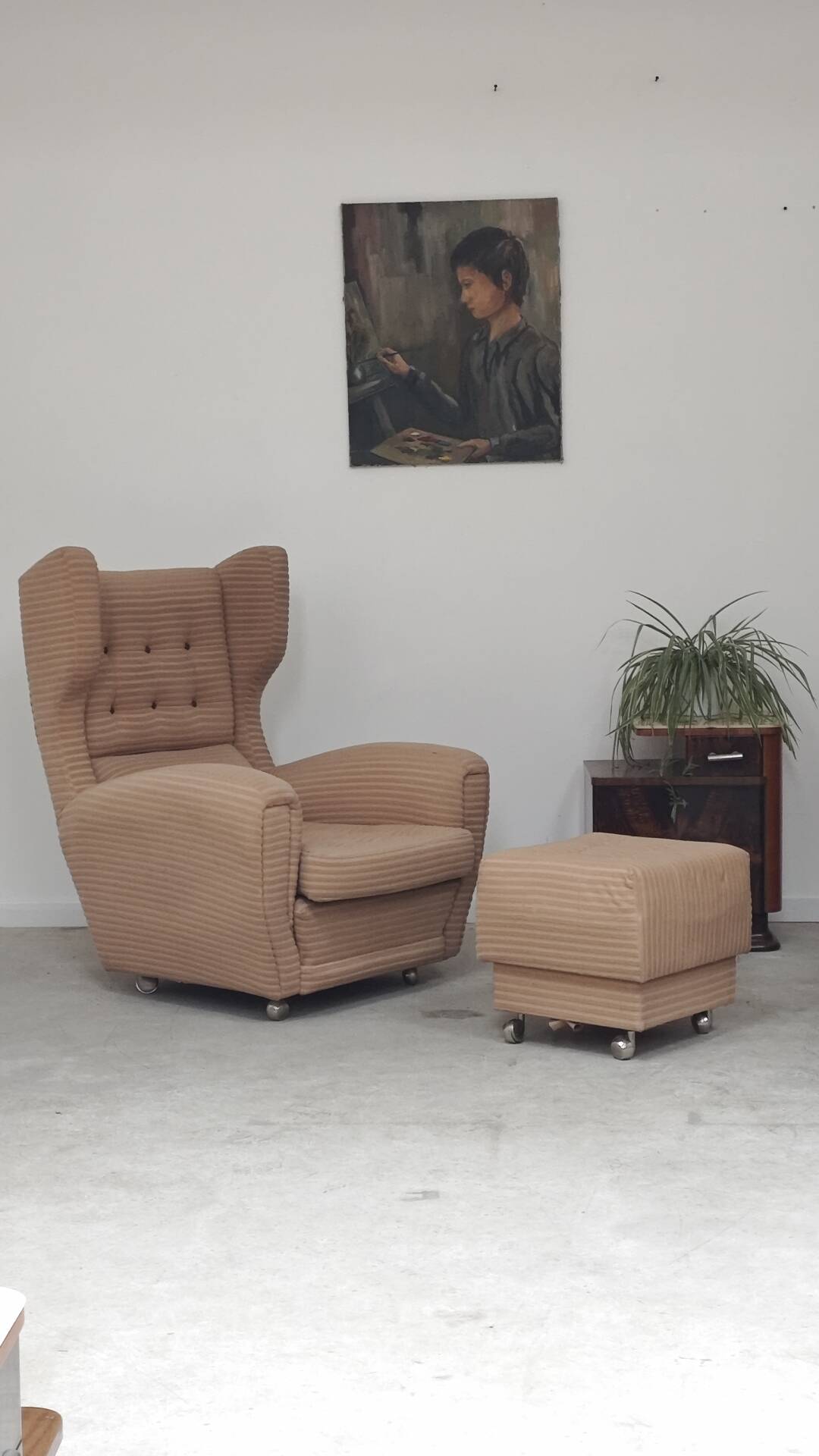 Beige wingback armchair and TVAR footrest, former Czechoslovakia.