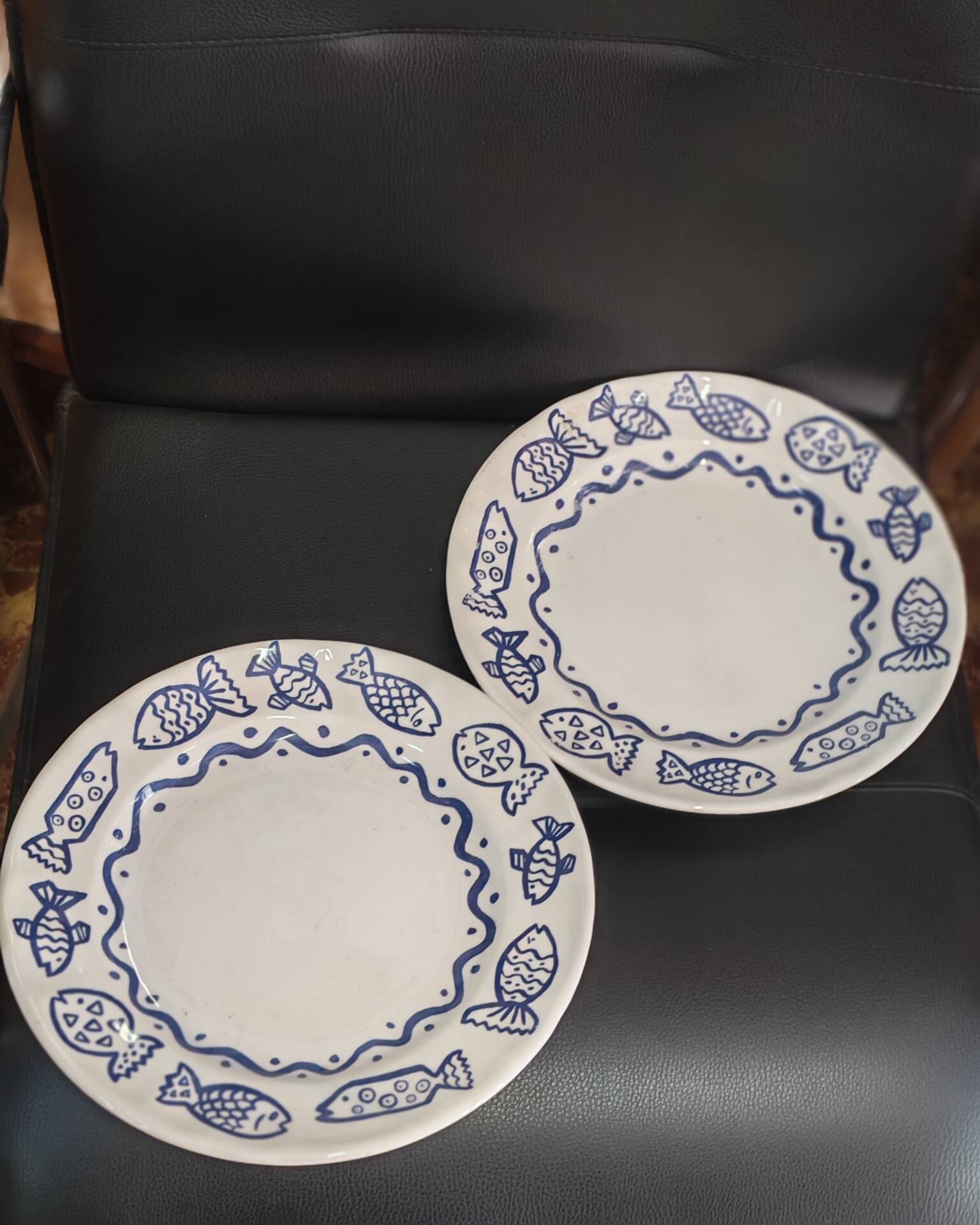 Pair of Castellania plates from Italy with blue fish decoration.