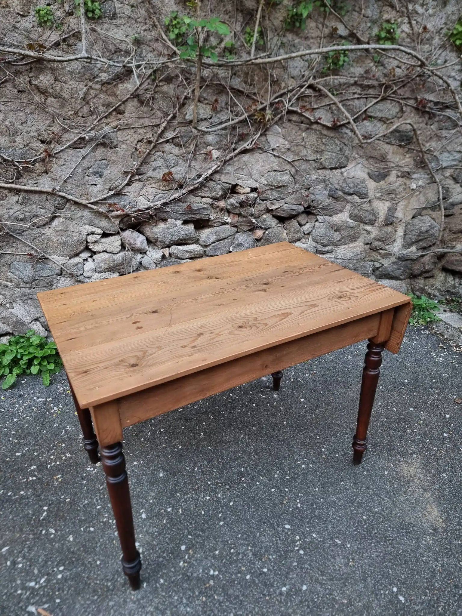 Vintage pine table with drop-leaf extension and turned beech legs, France, 1930s.