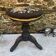 Old adjustable piano stool, blackened wood, metal screws, embroidered seat.