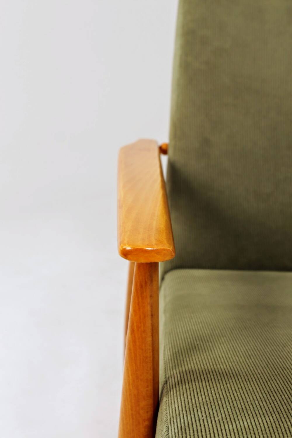 Mid-century modern design armchair in olive green corduroy.