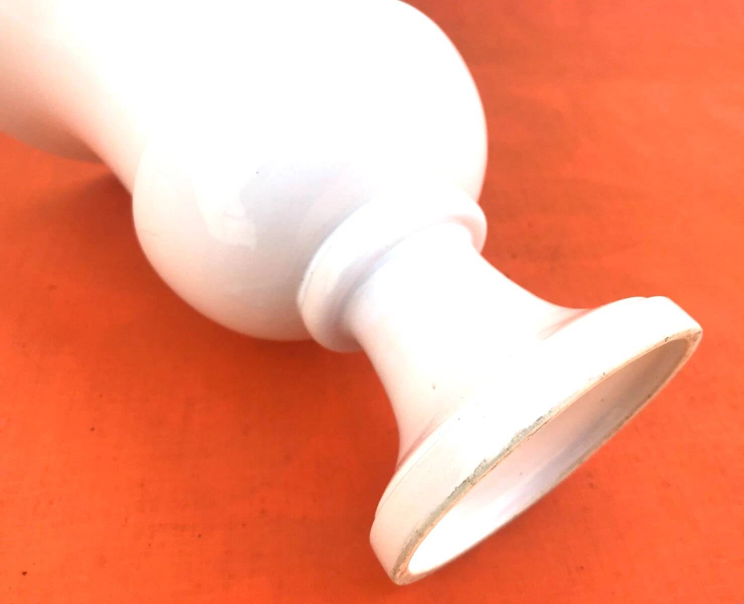 Vase on a pedestal, glazed white ceramic.