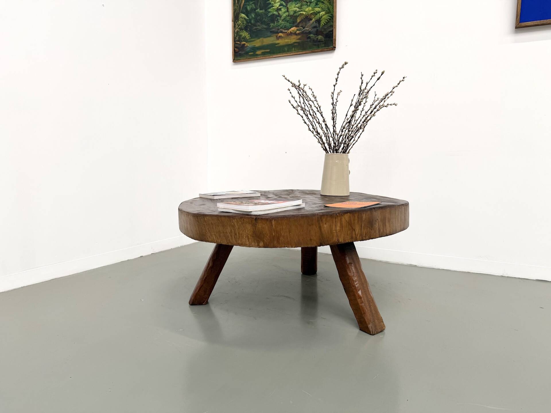 Brutalist coffee table in solid teak, monolithic slab, tripod base.