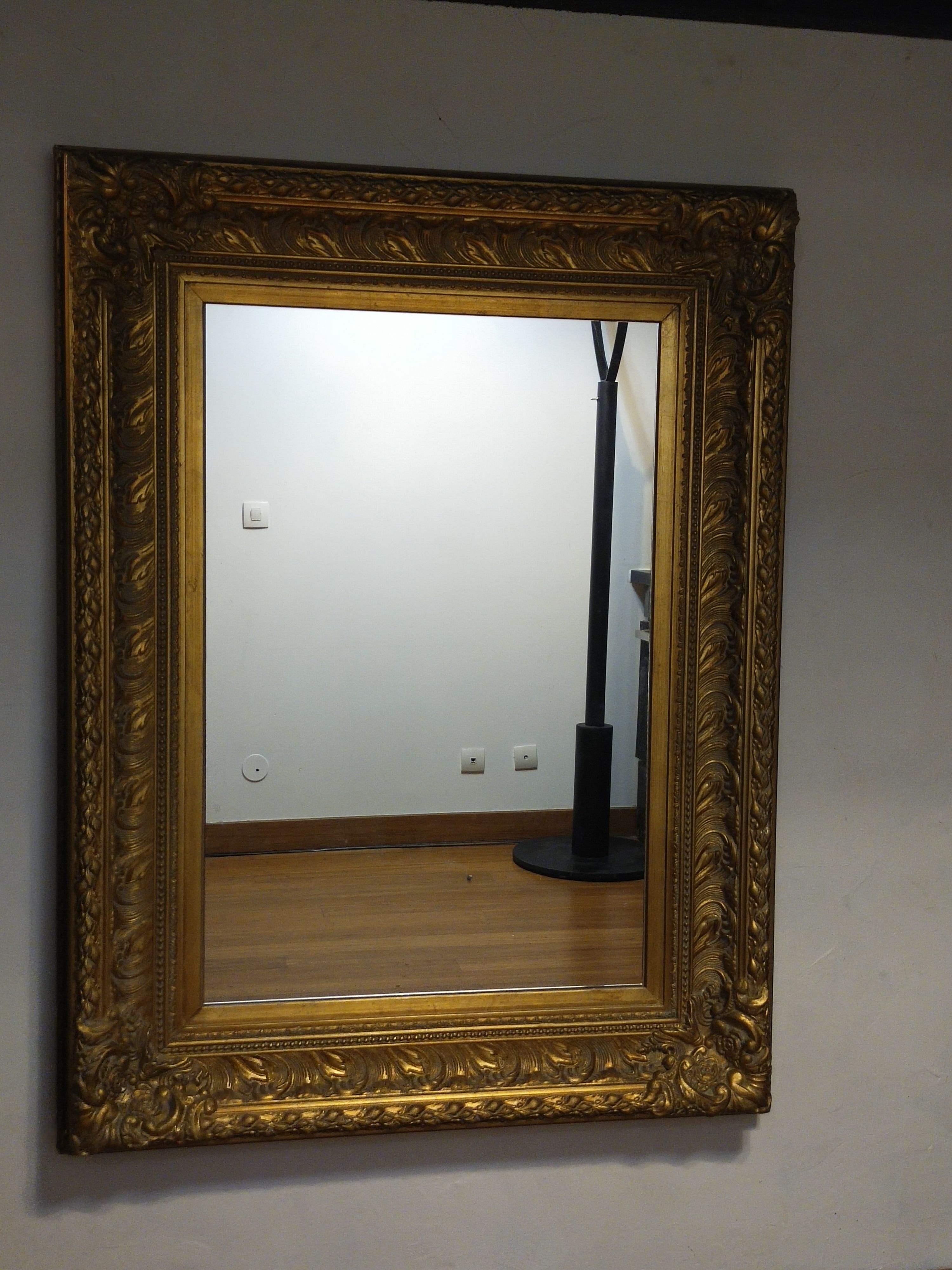Mirror with large molded frame in gilded plaster with gold leaf
