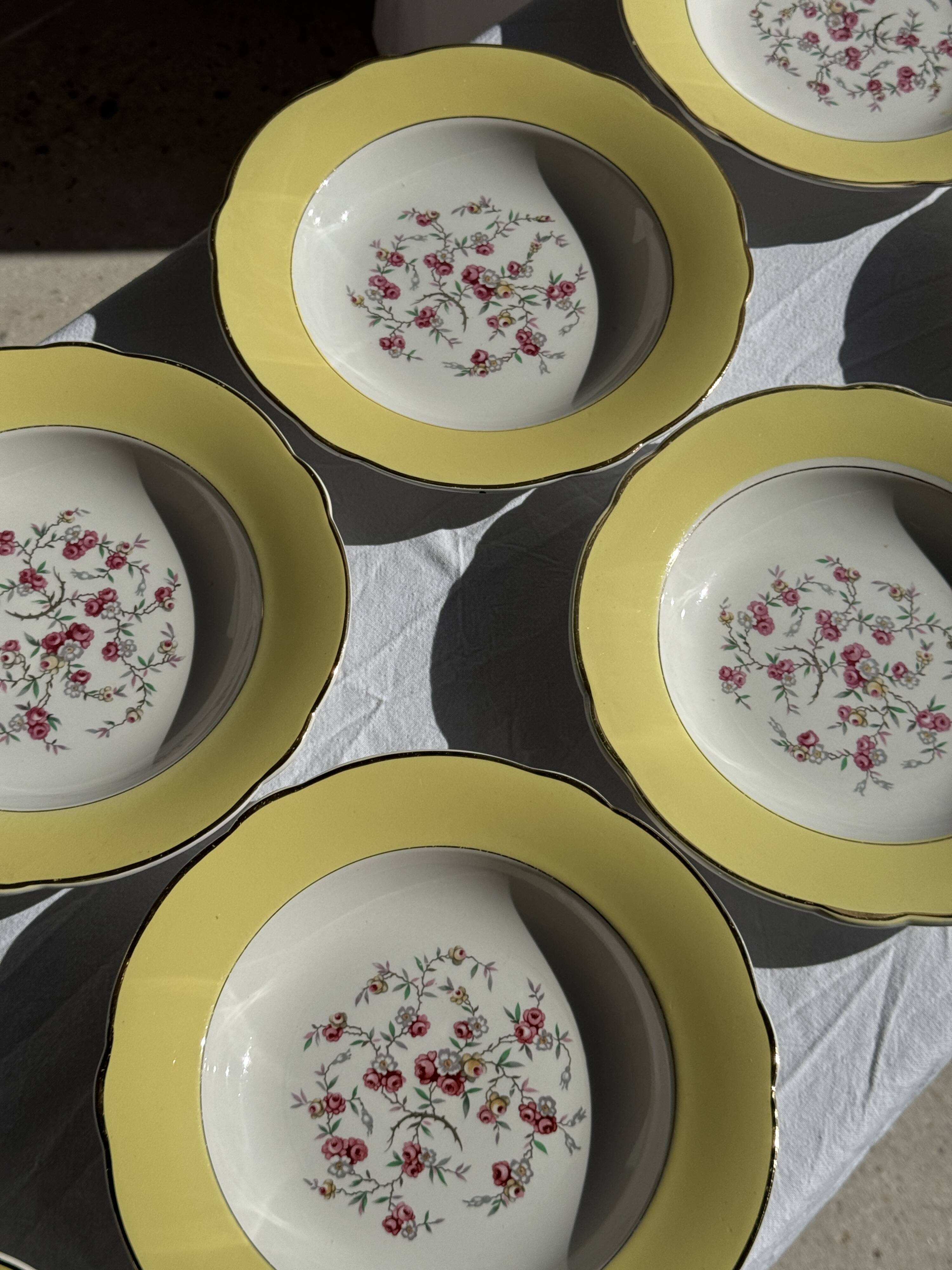 Set of 9 large vintage yellow deep plates with pink flowers and a gold rim.