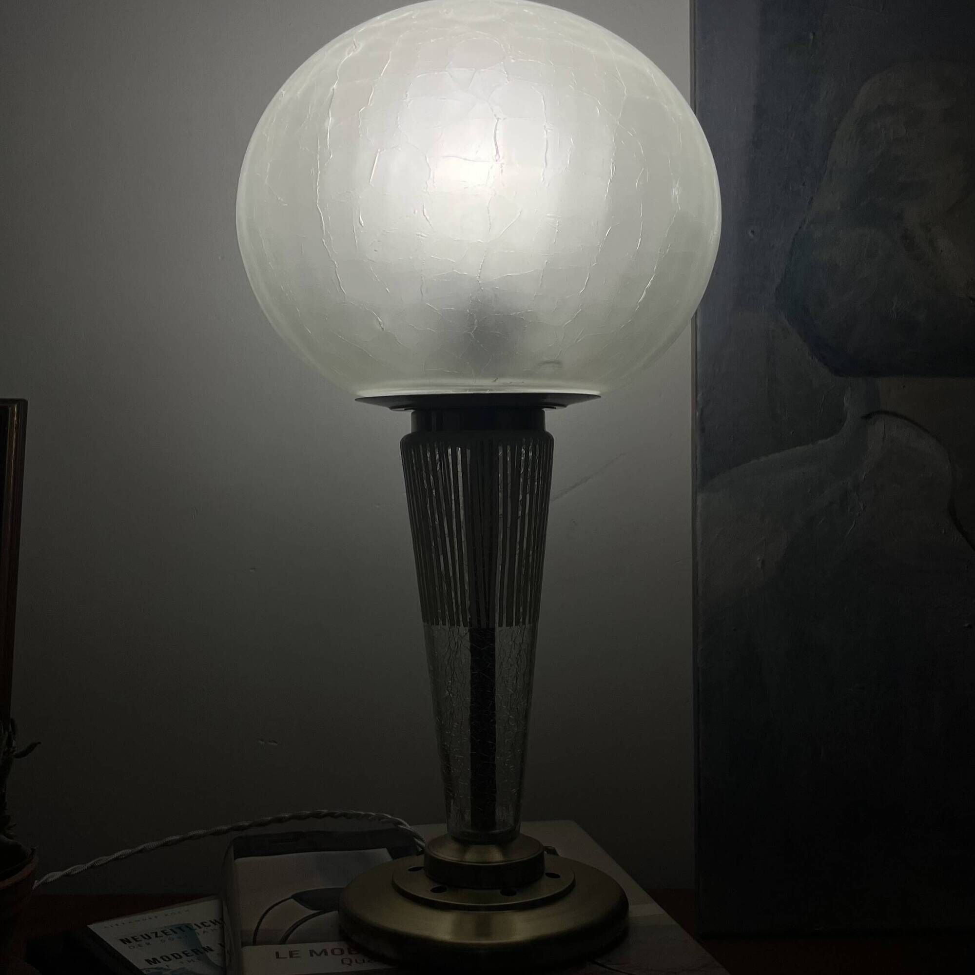 Large globe table lamp with a cracked glass base and brass stand.