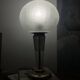 Large globe table lamp with a cracked glass base and brass stand.