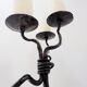 Large wrought iron candelabrum with an abstract design and three candle holders.