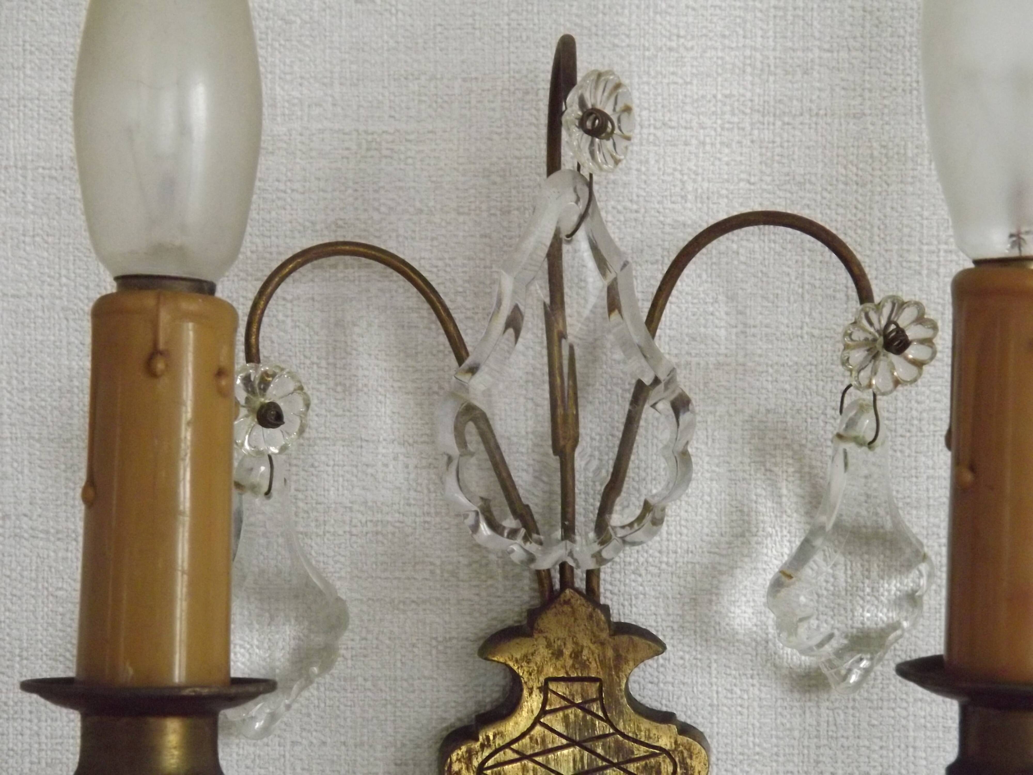 Pair of French antique brass double wall lights with assorted crystals.