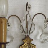 Pair of French antique brass double wall lights with assorted crystals.