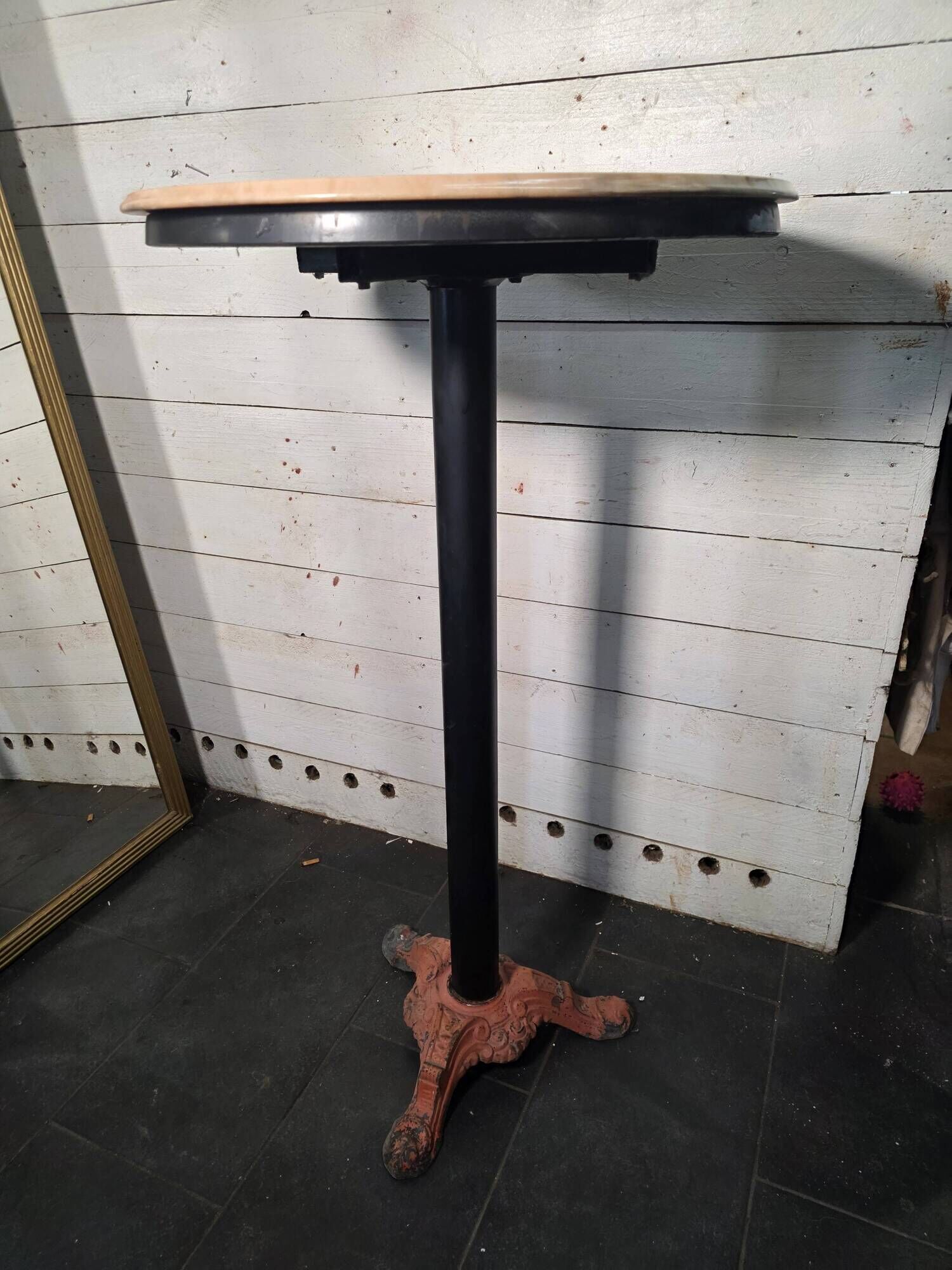 Bistro standing table with marble top and cast iron base.