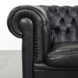 Comfortable black chesterfield armchair made of cowhide leather