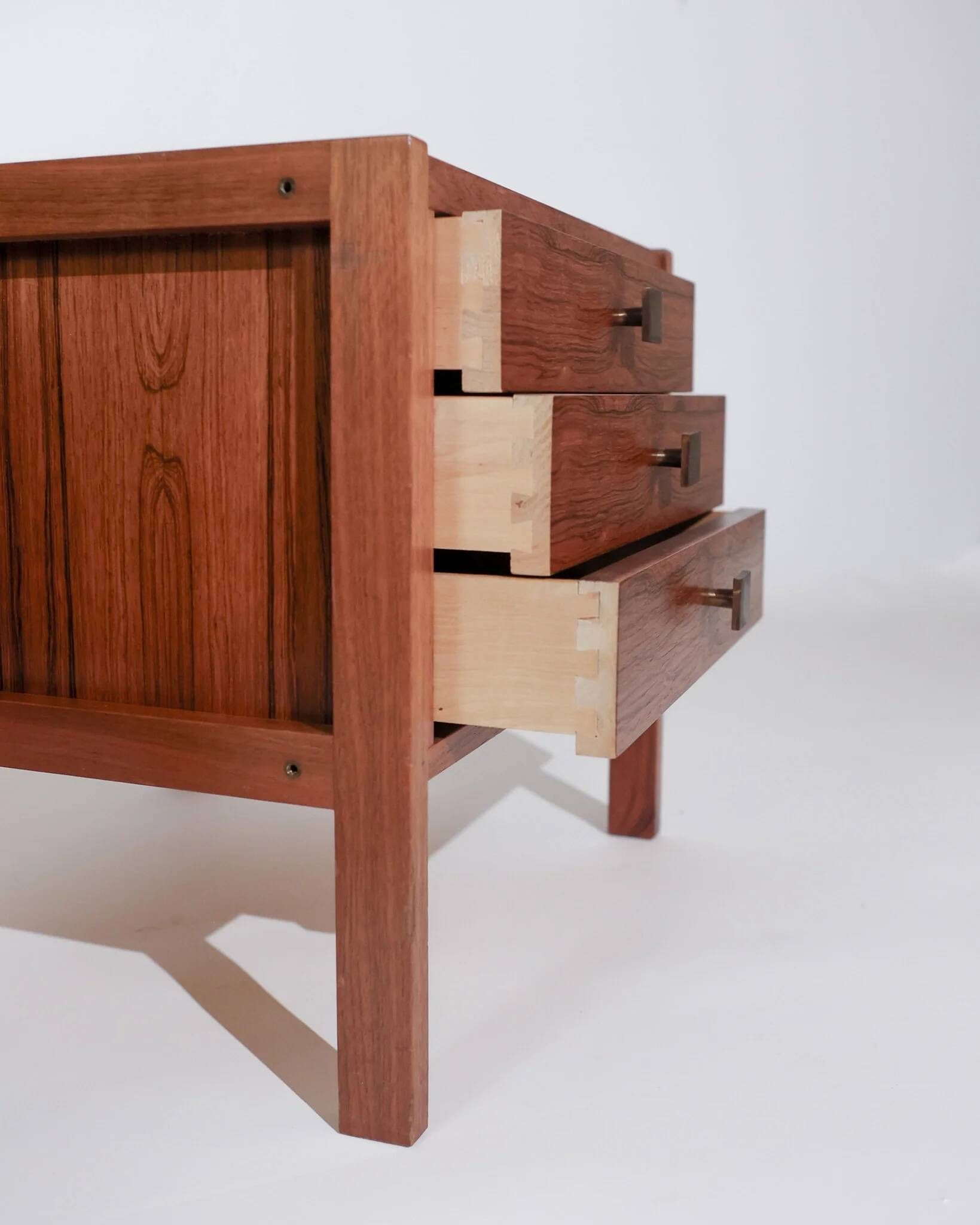 Pair of vintage Scandinavian bedside tables, three drawers, honey-toned wood.