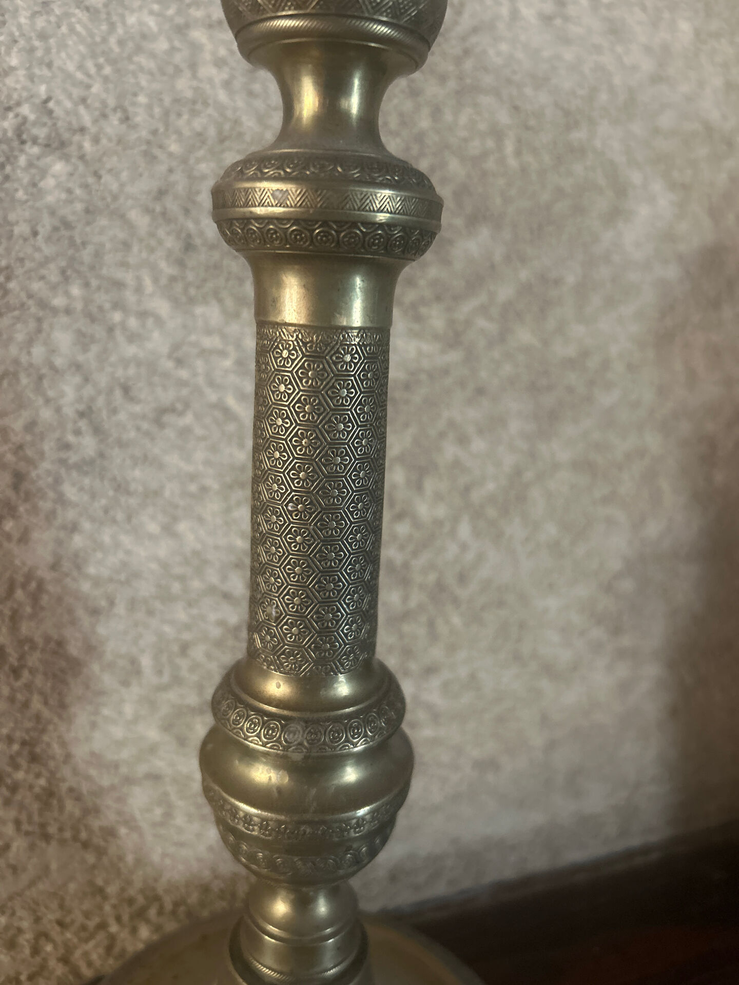 Large antique brass candlestick with floral decoration.