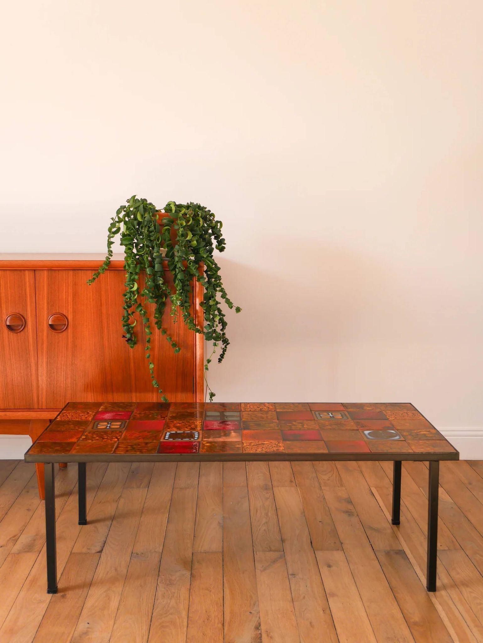 Ceramic and black iron coffee table, attributed to the Roche-Bobois brand, with a black metal base and structure, rectangular ceramic top from Vallauris with colourful patterns in ochre and orange, design from the 1970s.