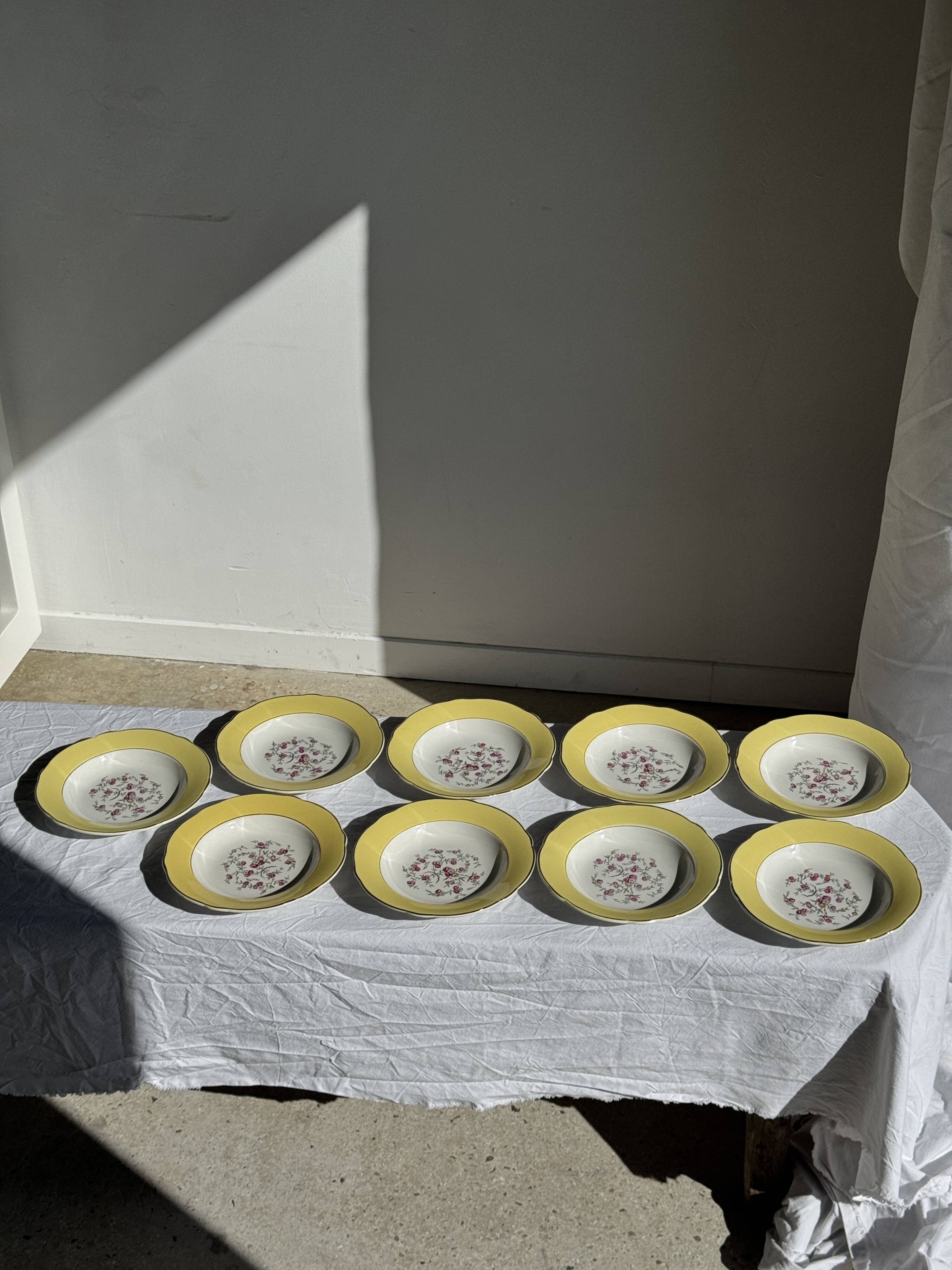 Set of 9 large vintage yellow deep plates with pink flowers and a gold rim.