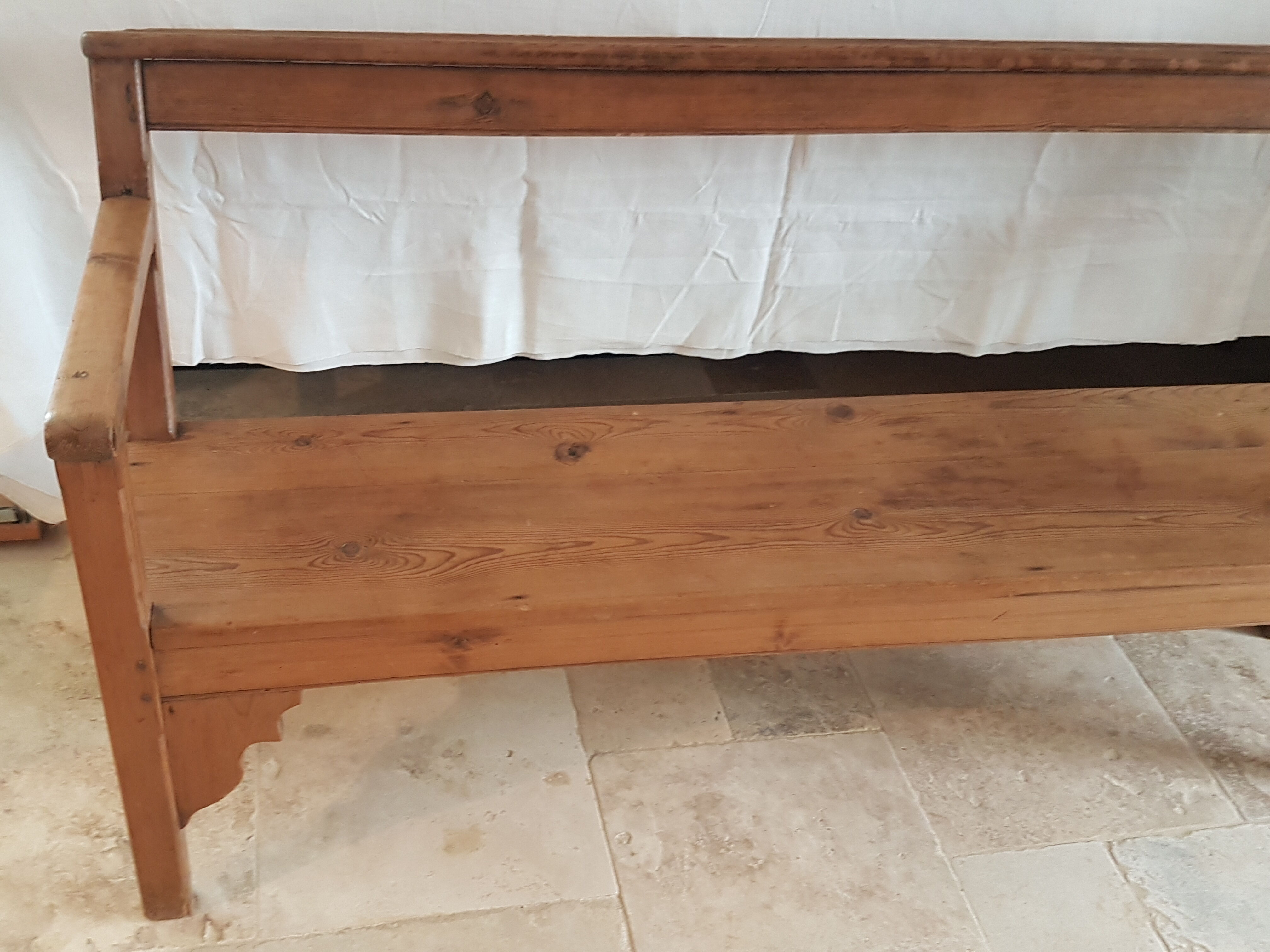 Church bench in fir tree with armrests