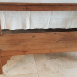 Church bench in fir tree with armrests