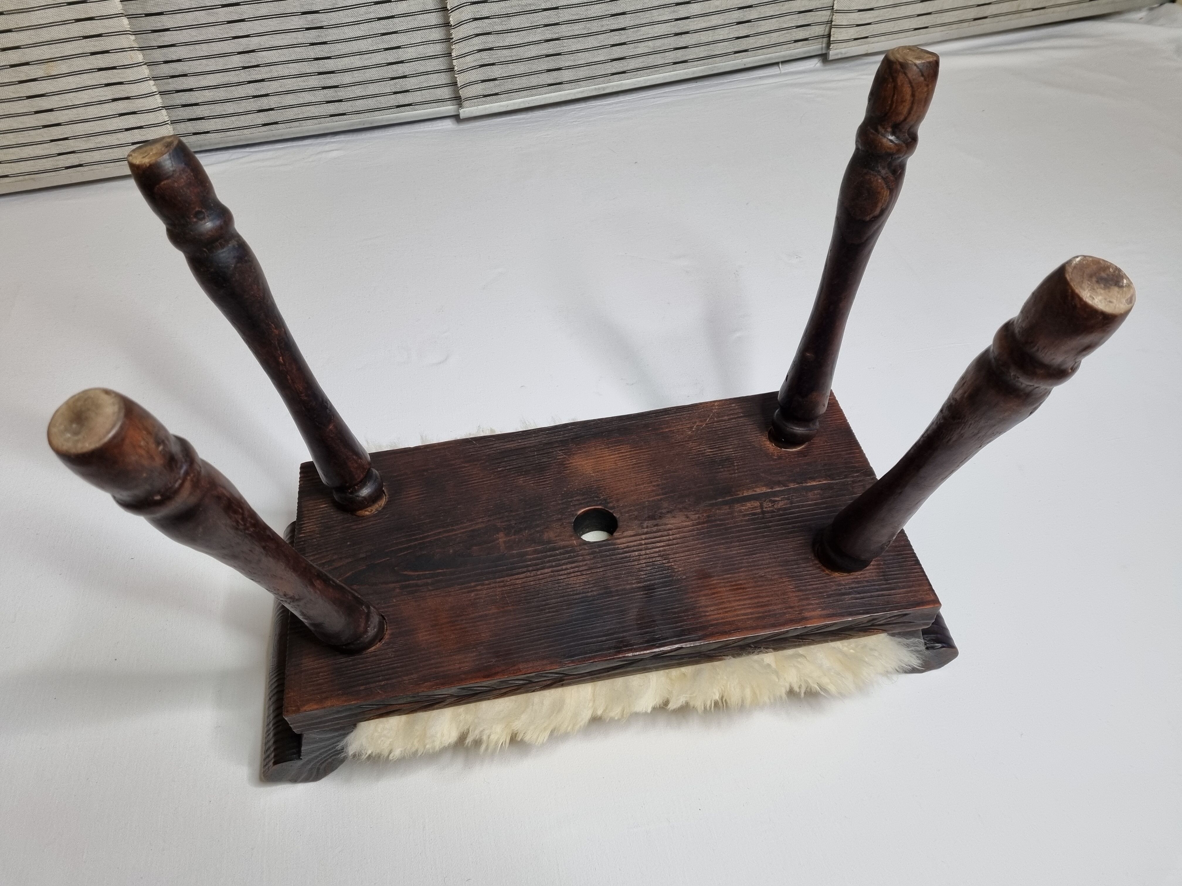 Carved wooden stool covered with Celtic-style sheepskin