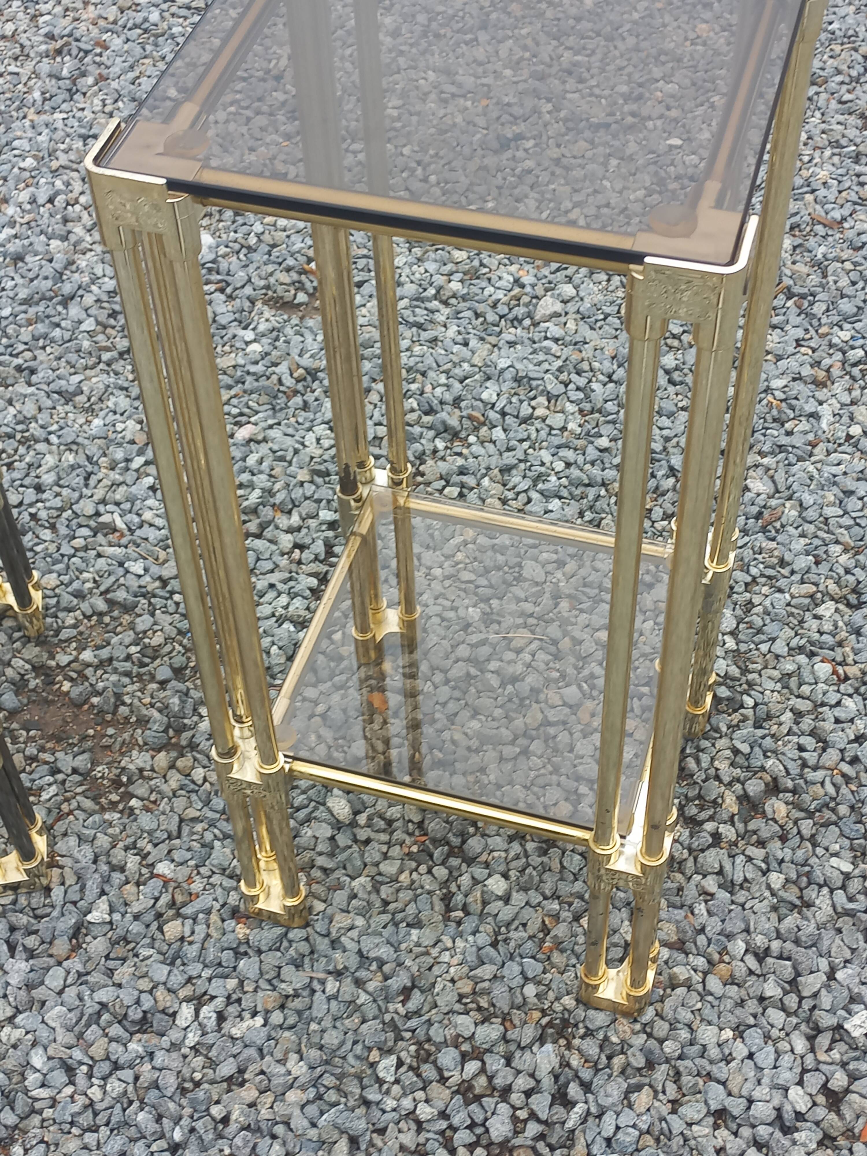 Pair of Hollywood Regency side tables in gold metal and smoked glass.