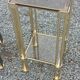 Pair of Hollywood Regency side tables in gold metal and smoked glass.