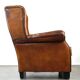 Very large worn sheepskin wing chair with a checked seat cushion