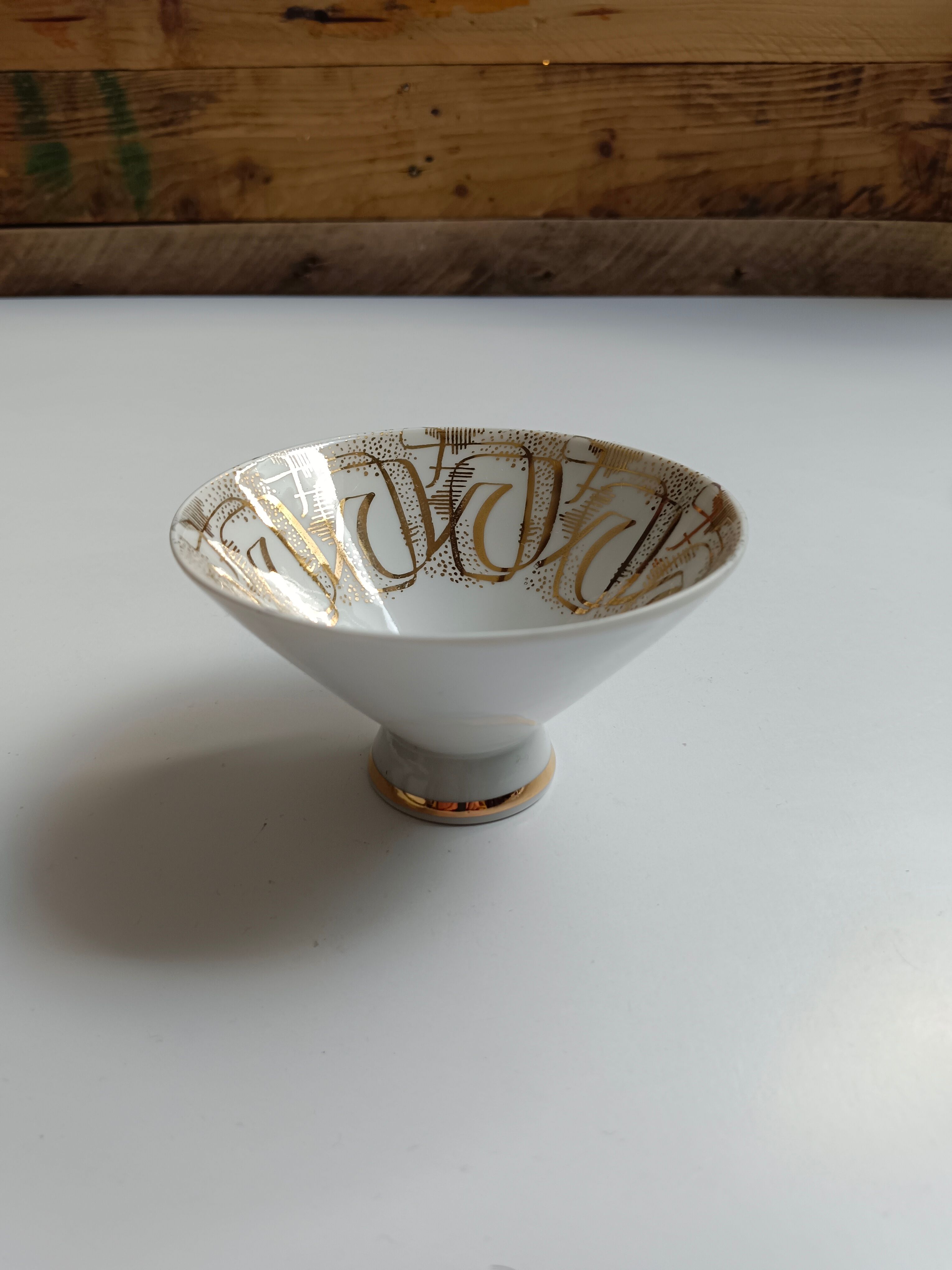 Solitaire tea cup, saucer, and dessert plate in white and gold.