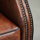 Sheepskin wingback armchair finished with black piping and a correct seat