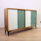 A vintage mid-century bookshelf/sideboard with green and white sliding door