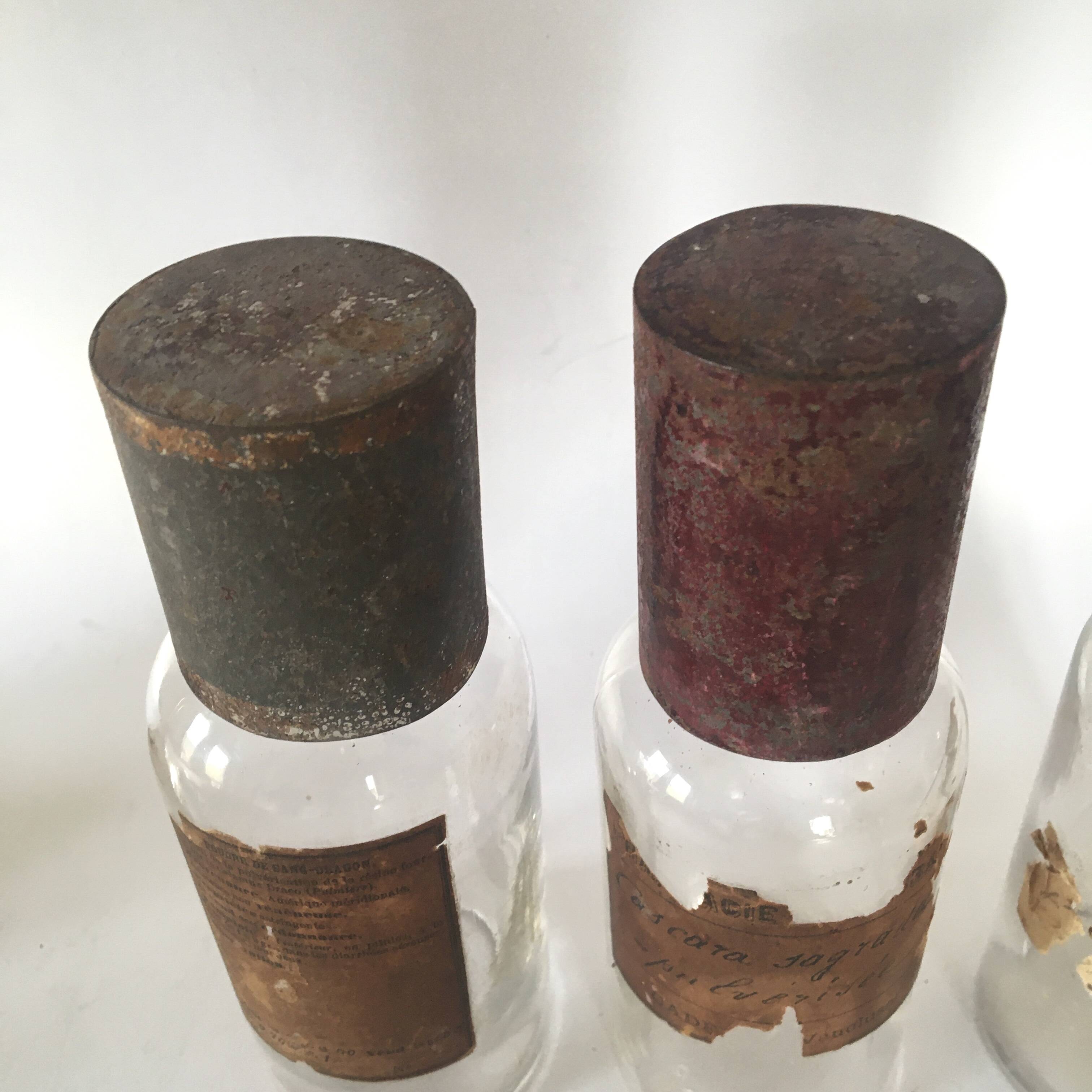 Trio apothecary bottles, painted metal caps