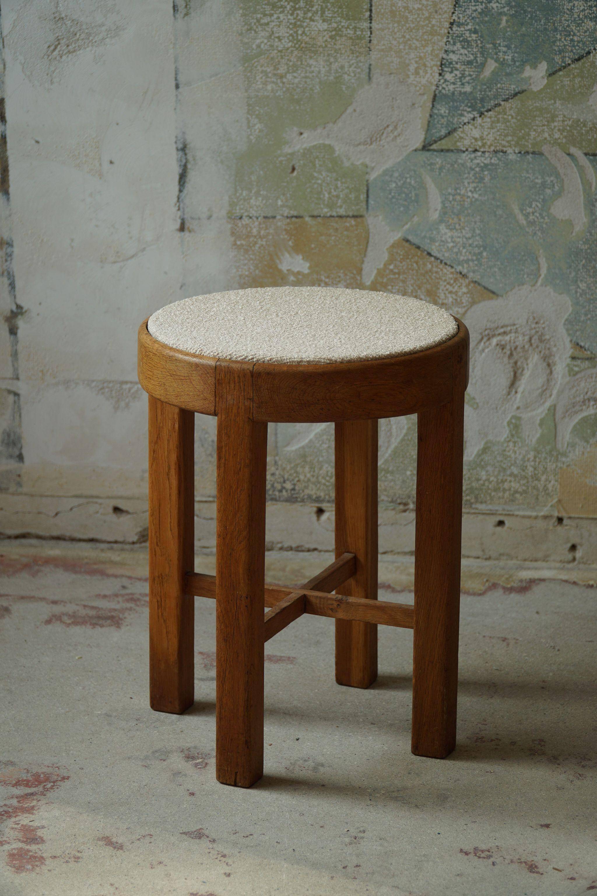 Mid-century Danish stool in oak, reupholstered in boucle wool, circa 1950.