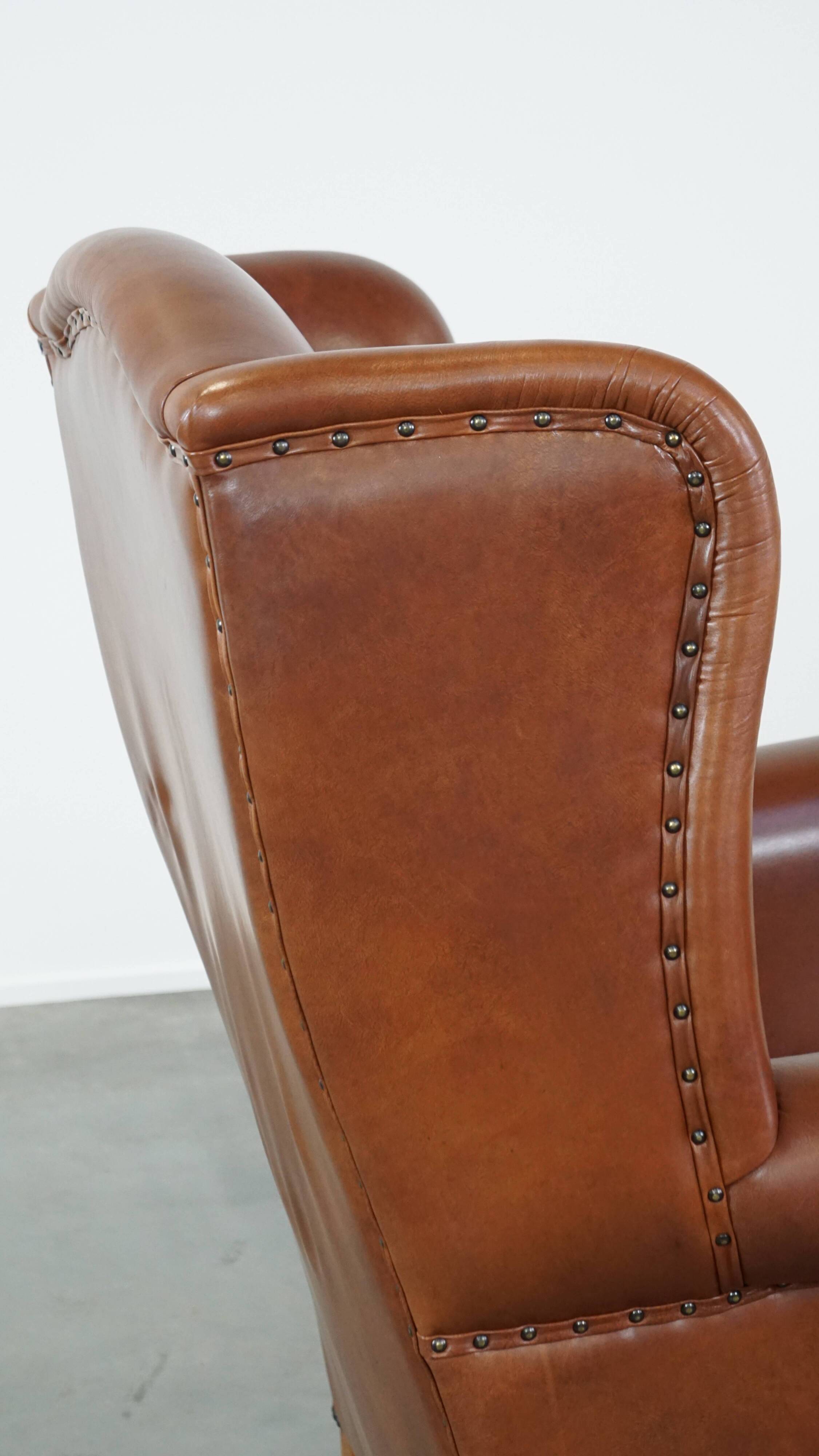 Cognac-colored leather wingback chair in English style