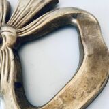 Bow-shaped brass trivet