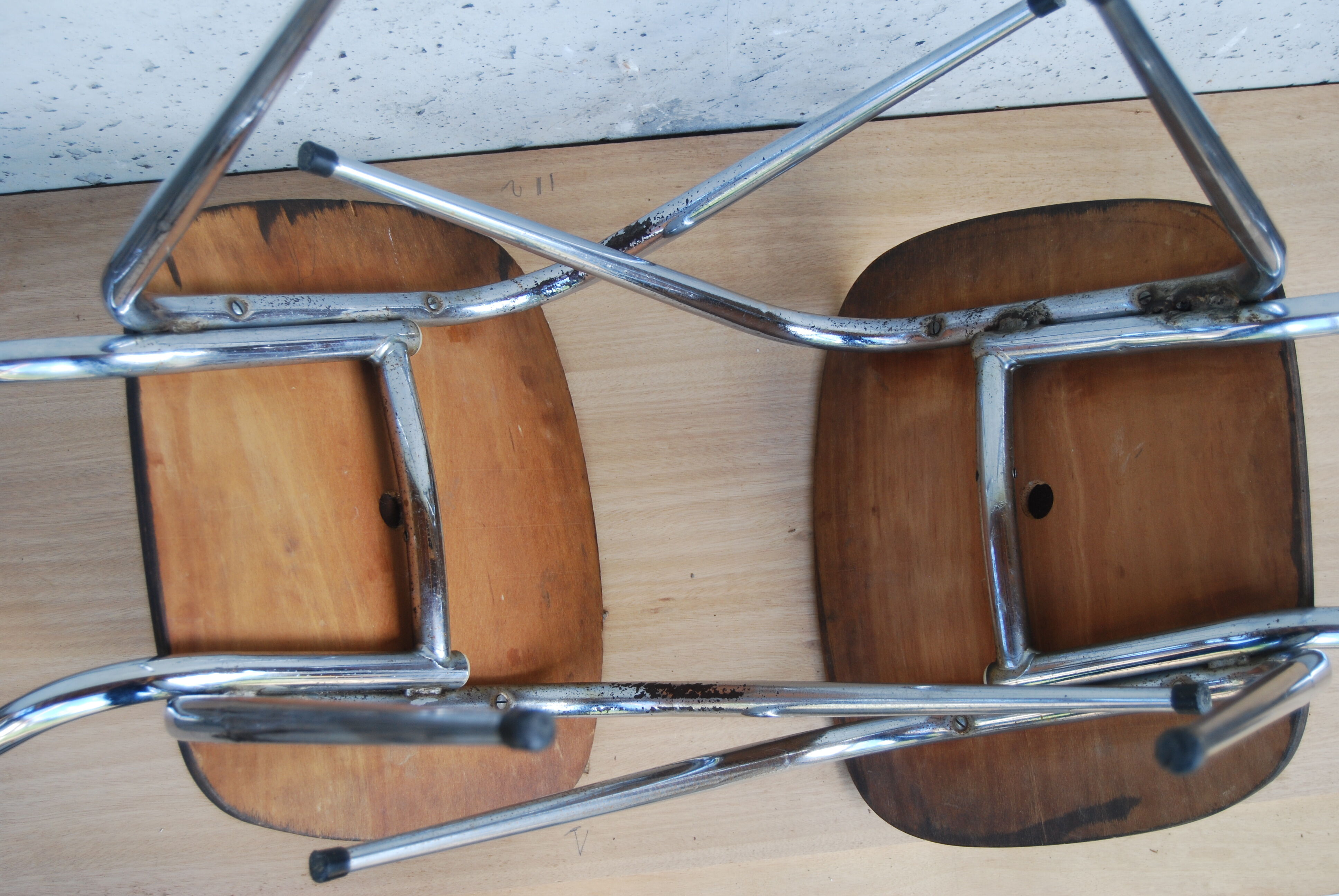 Pair of formica chairs with chrome metal backs in the shape of a lyre.