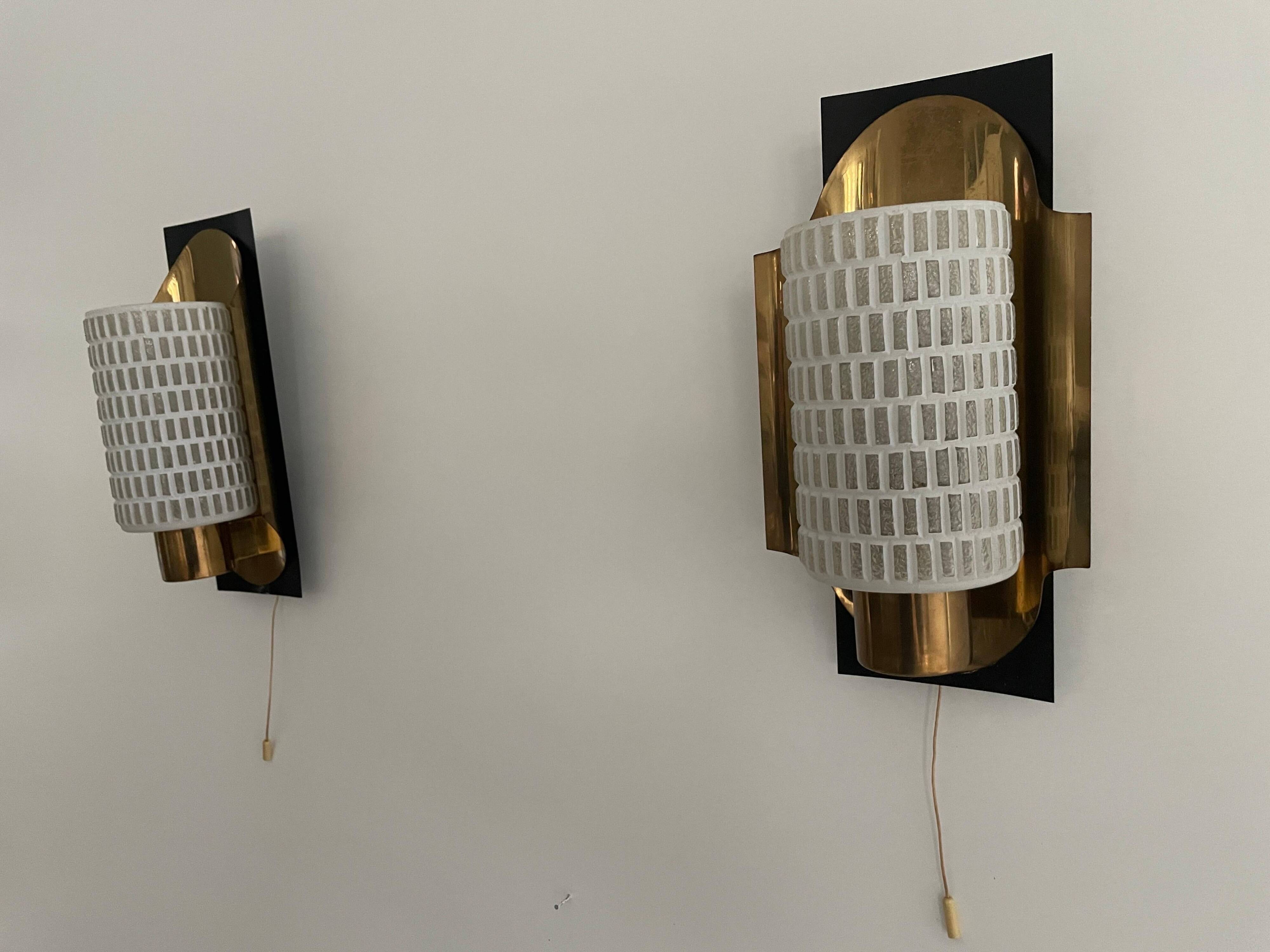 Mid-century pair of wall sconces in textured glass and brass, 1950s, Germany.