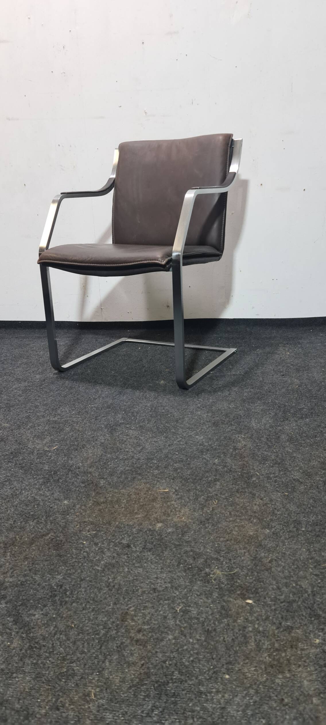 One of two vintage Leather and metal arm chairs.