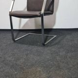 One of two vintage Leather and metal arm chairs.