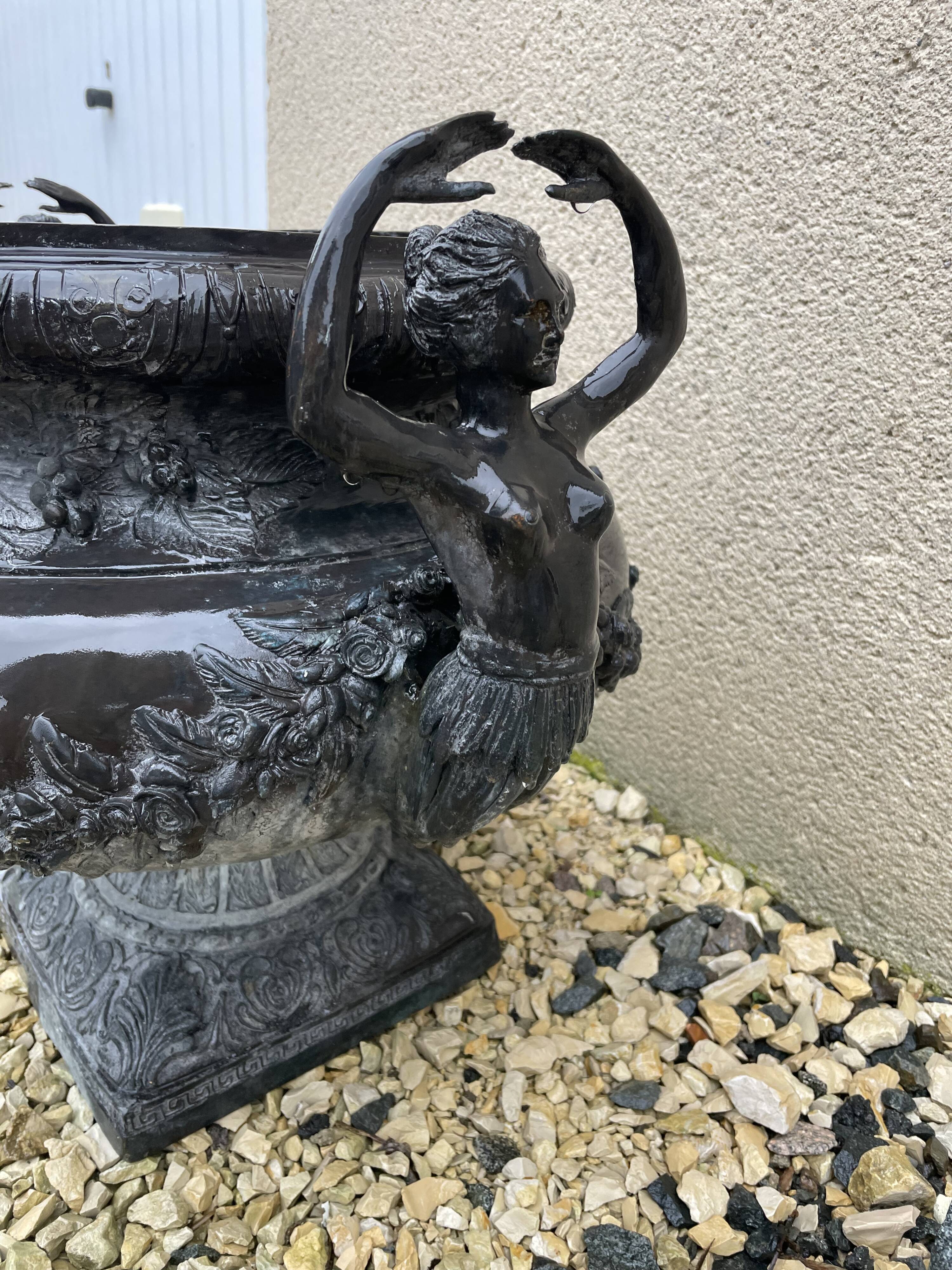 Cast iron vase decorated with mermaids.