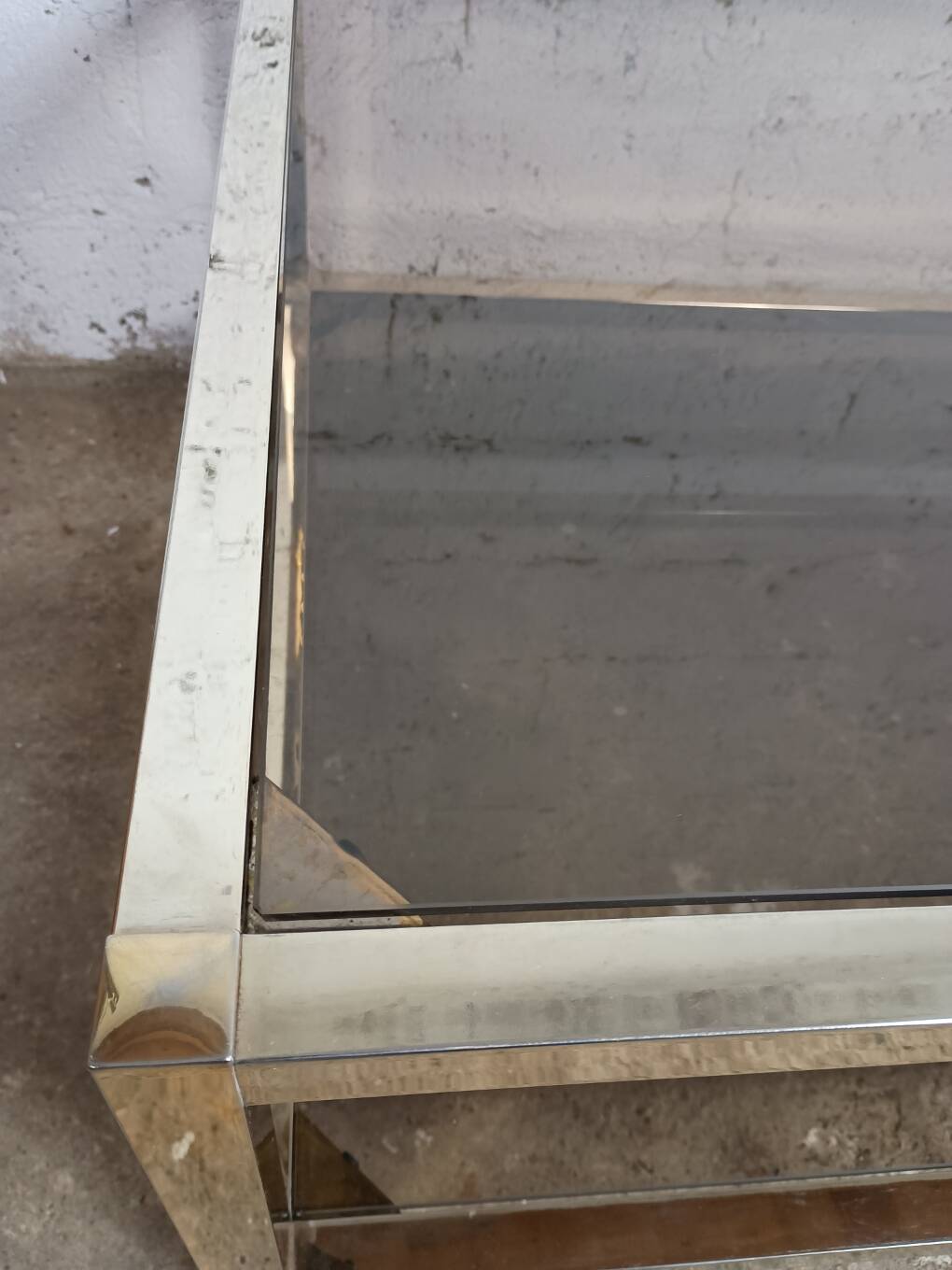 1970s coffee table in brass with a double smoked glass top.