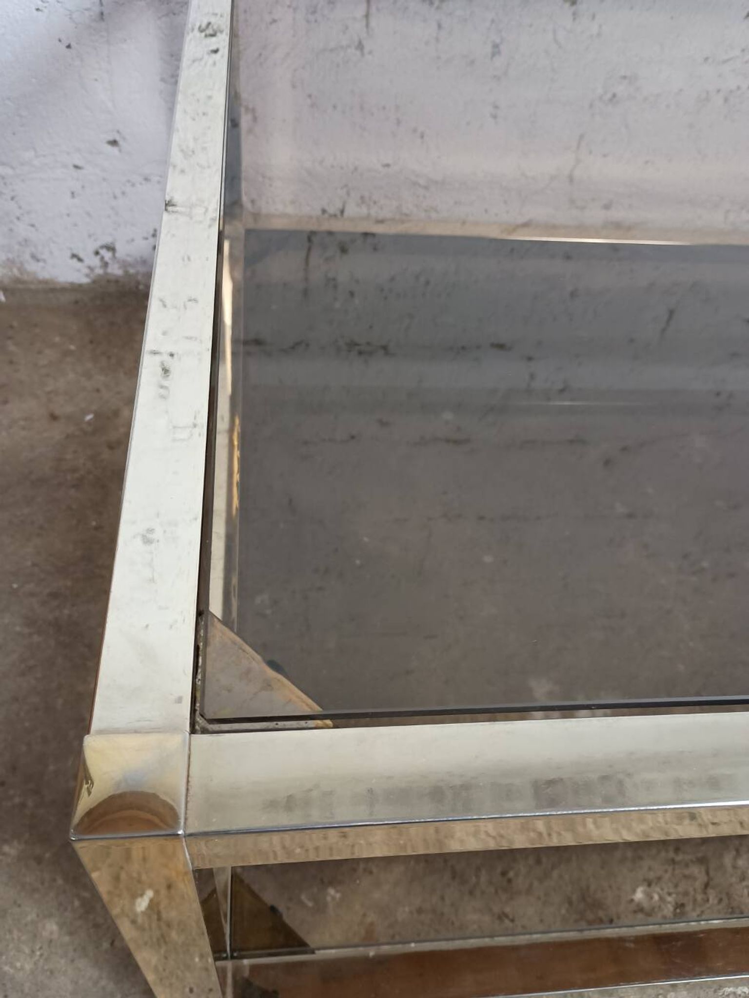 1970s coffee table in brass with a double smoked glass top.
