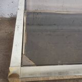 1970s coffee table in brass with a double smoked glass top.