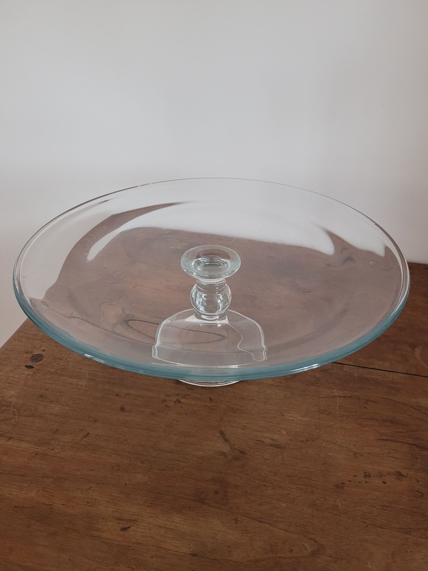 Large glass display plate mounted on a stand.