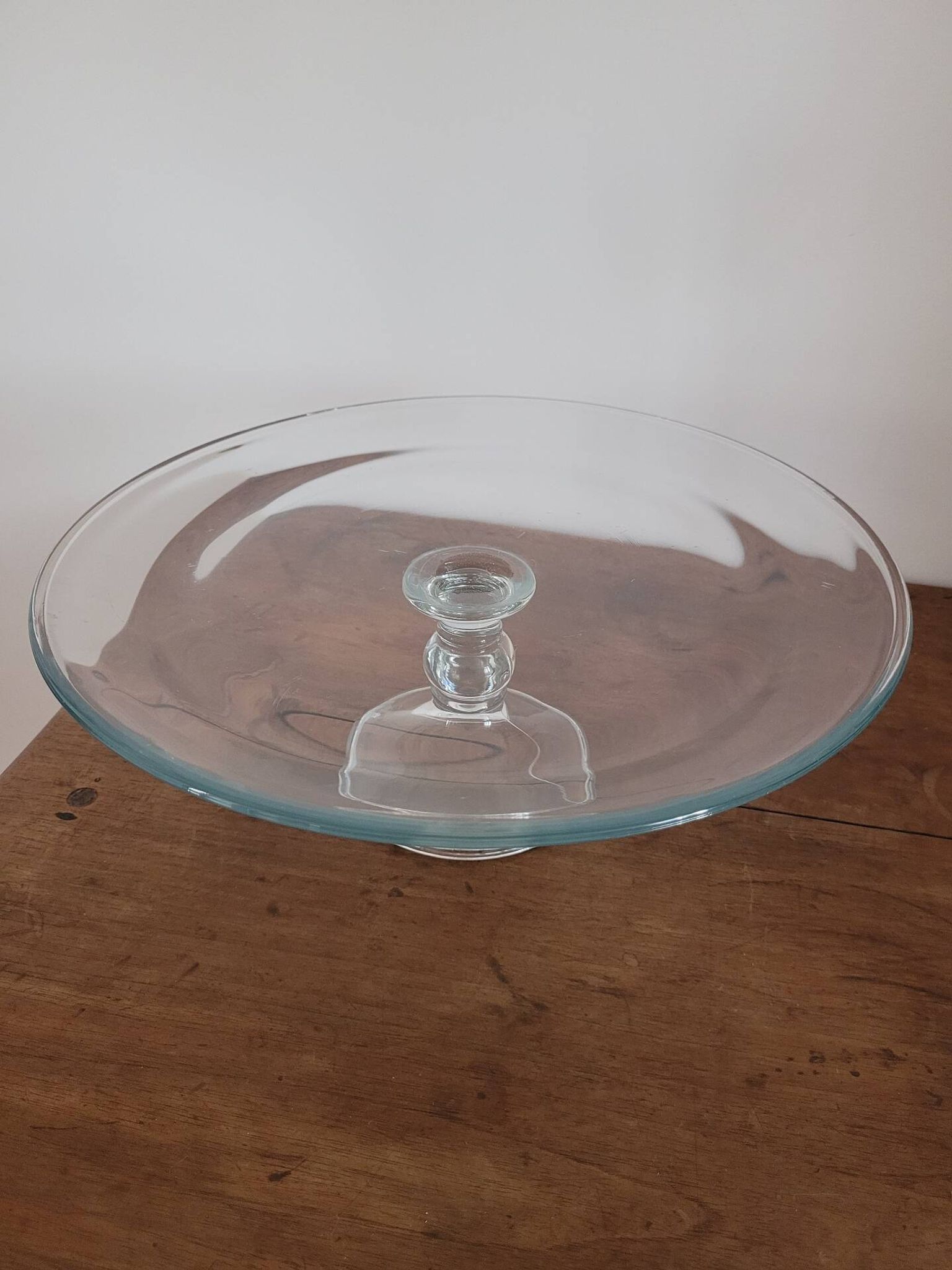 Large glass display plate mounted on a stand.