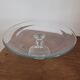 Large glass display plate mounted on a stand.