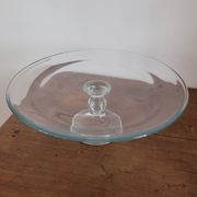 Large glass display plate mounted on a stand.